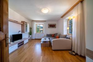 a living room with a couch and a tv at Ferienwohnung Brunjaunhof in Schenna