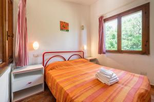 a bedroom with a bed and a window at Accu is Prezzus E special 50m mare in Villasimius