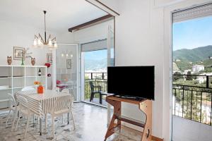 a living room with a television and a table with chairs at Condominio Sereno in Rapallo