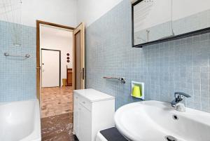 a bathroom with a white sink and blue tiles at Condominio Sereno in Rapallo +23 photos
