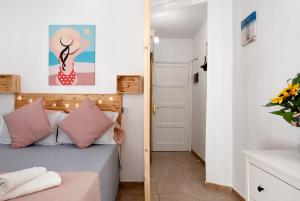 a small bedroom with a bed with pink pillows at Vista Al Paraíso in El Pris