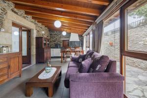 a living room with a purple couch and a table at O Pozo in Ordes