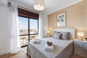 a bedroom with a bed and a large window at Dreamalvor in Alvor +16 photos