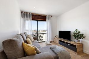 a living room with a couch and a flat screen tv at Dreamalvor in Alvor
