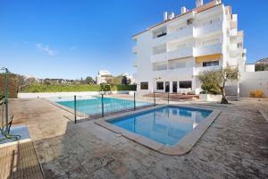 a swimming pool in front of a building at Dreamalvor in Alvor