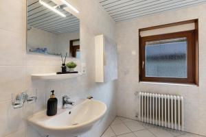 a white bathroom with a sink and a window at Ferienhof Brutoni in Bad Peterstal-Griesbach +29 photos