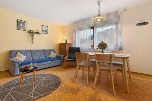 a living room with a blue couch and a table and chairs at Ferienhof Brutoni in Bad Peterstal-Griesbach