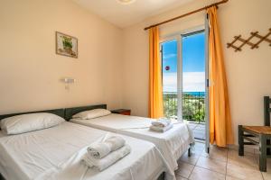 two beds in a room with a view of the ocean at Anemona apartment 1 in Kefallonia