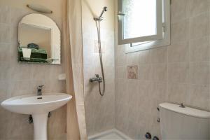 a bathroom with a sink and a toilet and a shower at Anemona apartment 1 in Kefallonia +14 photos