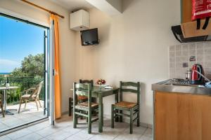 a kitchen with a table and a balcony at Anemona apartment 1 in Kefallonia