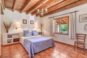 a bedroom with a bed and a chair and a window at Can Vaja in Pollença +20 photos
