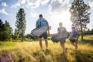 a man and two children walking in a field with their luggage at 18221-2 Forestbrook Loop in Sunriver