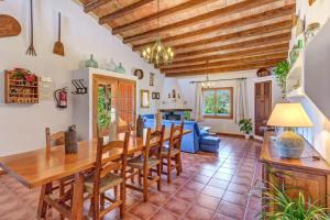 a kitchen and dining room with a wooden table and chairs at Can Vaja in Pollença