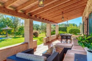 an outdoor patio with a wooden pergola at Can Vaja in Pollença