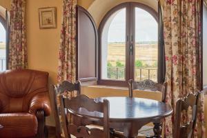 a room with a table and a chair and a window at Apartamentos Valsequillo Córdoba in Valsequillo