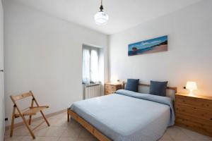 a bedroom with a bed and a chair in it at Trilocale San Nazario in Varazze
