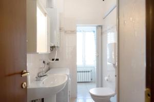 a white bathroom with a sink and a toilet at Trilocale San Nazario in Varazze