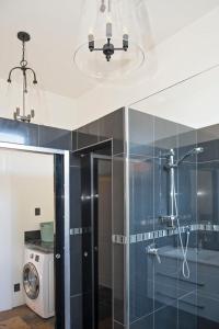 a bathroom with a glass shower and a washer at The Empire Hotel in Timaru