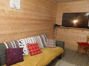 a living room with a couch and a flat screen tv at Ancienne petite ferme in Châtelblanc