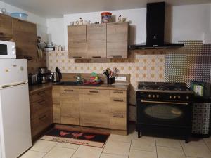 a kitchen with wooden cabinets and a black stove top oven at Ancienne petite ferme in Châtelblanc