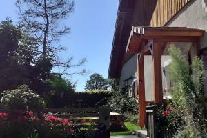 a garden next to a building with a fence and flowers at Ancienne petite ferme in Châtelblanc +5 photos
