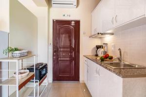 a kitchen with a sink and a brown door at Apartment Iole in Póndi +20 photos