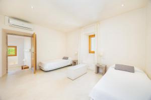a white bedroom with two beds and a tub at Casa Con Piscina En Selva in El Port de la Selva +29 photos