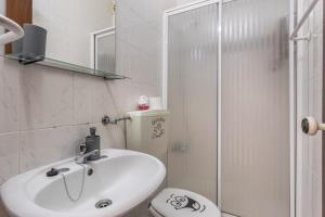 a white bathroom with a sink and a shower at Geo House in Vila do Bispo +12 photos