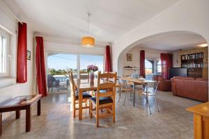 a dining room and living room with a table and chairs at Brisa do Mar in Carvoeiro