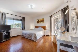 a bedroom with a bed and a flat screen tv at Brisa do Mar in Carvoeiro +22 photos