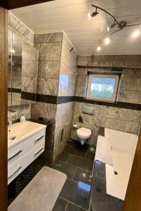 a bathroom with a sink and a toilet at Ferienwohnungen in Lohr in Lohr am Main +15 photos