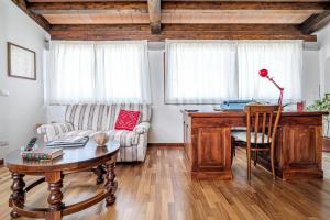a living room with a desk and a couch at Camere La Ro Ca- Telti in Telti