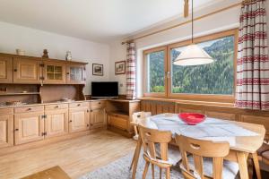 a kitchen with a table and chairs and a window at Cësa Gravina Jubas in Ortisei +15 photos
