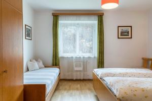a small bedroom with a bed and a window at Cësa Gravina Jubas in Ortisei