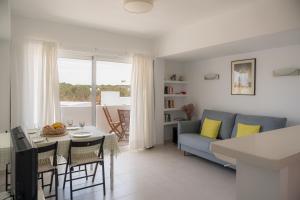 a living room with a blue couch and a table at Mirada I in Es Pujols