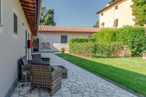 a patio with wicker chairs and a yard at Il Borghetto Bed and Breakfast in Borgo San Lorenzo