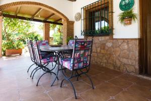 a patio with a wooden table and chairs at La Huerta Del Sur in Alhaurín el Grande