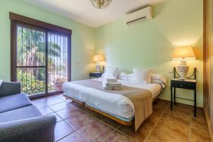 a bedroom with a bed and a couch and a window at La Huerta Del Sur in Alhaurín el Grande +21 photos