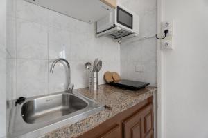 a kitchen with a sink and a microwave at Loft Pension Candelaria in Valle Gran Rey +37 photos