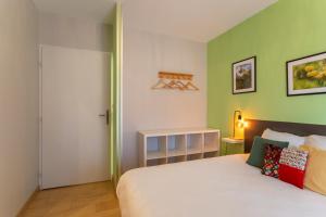 a bedroom with a white bed and green walls at Chambre - Lis in Aroue