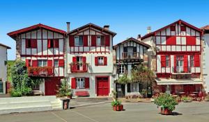 a group of buildings with red and white at Chambre - Lis in Aroue