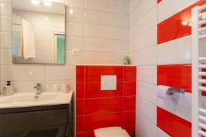 a bathroom with red and white tiles and a sink at Chambre - Lis in Aroue