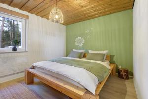 a bedroom with a large bed in a green wall at Ferienhaus am Neubäuer See in Roding