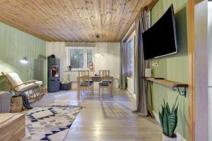 a living room with a television and a dining room at Ferienhaus am Neubäuer See in Roding