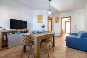 a living room with a table and a blue couch at Albachiara Sul Mare in Porto Torres