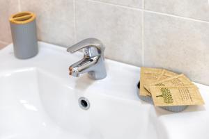 a bathroom sink with a faucet and a newspaper at Albachiara Sul Mare in Porto Torres +24 photos
