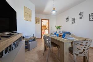 a dining room with a wooden table and chairs at Albachiara Sul Mare in Porto Torres