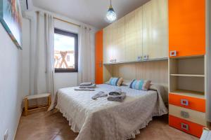 a bedroom with a bed with orange walls and a window at Albachiara Sul Mare in Porto Torres