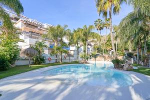 a swimming pool in a yard with palm trees at La Casita Azul in Almuñécar