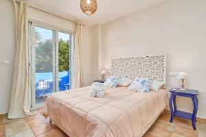 a bedroom with a large bed and a large window at La Casita Azul in Almuñécar